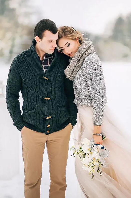 a rustic groom's outfit with a plaid shirt, beige jeans, a black cardigan is a cool idea for a cozy winter wedding