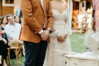 a simple and stylish look with a white shirt, a rust-colored blazer, navy pants, brown shoes and a watch for a boho wedding