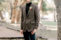a simple boho winter groom look with a black turtleneck, a brown plaid blazer, navy pants, brown shoes and a bold boutonniere