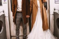 a white shirt, grey windowpane pans, brown boots and a brown coat are a great modern groom’s look for a wedding