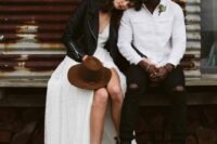 a white shirtjacket, black ripped jeans, black combat boots and a black hat are a lovely and cool outfit for a fall wedding