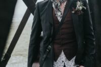 an alternative groom’s look with a printed shirt, a brown waistcoat, a black blazer, a neck tie, a black hat and a boutonniere