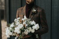 burgundy velvet pants and a matching turtleneck, a brown plaid blazer and a boutonniere for a casual winter groom’s look