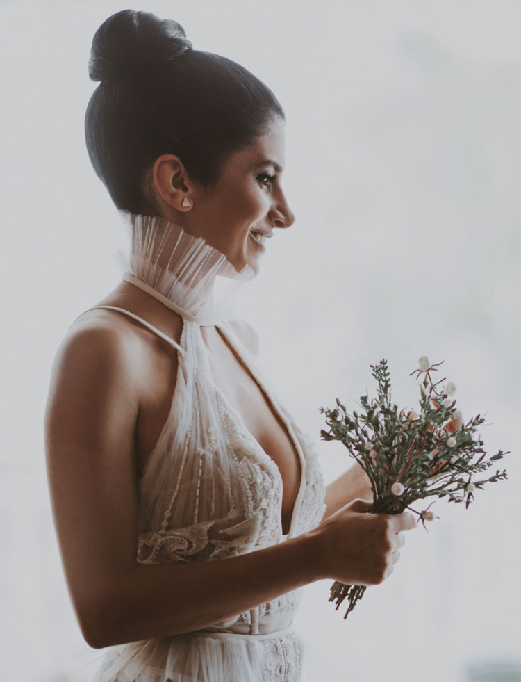 The bride was wearing a custom-made wedding dress with a plunging neckline, an ioen back, a ruffle collar and statement earrings