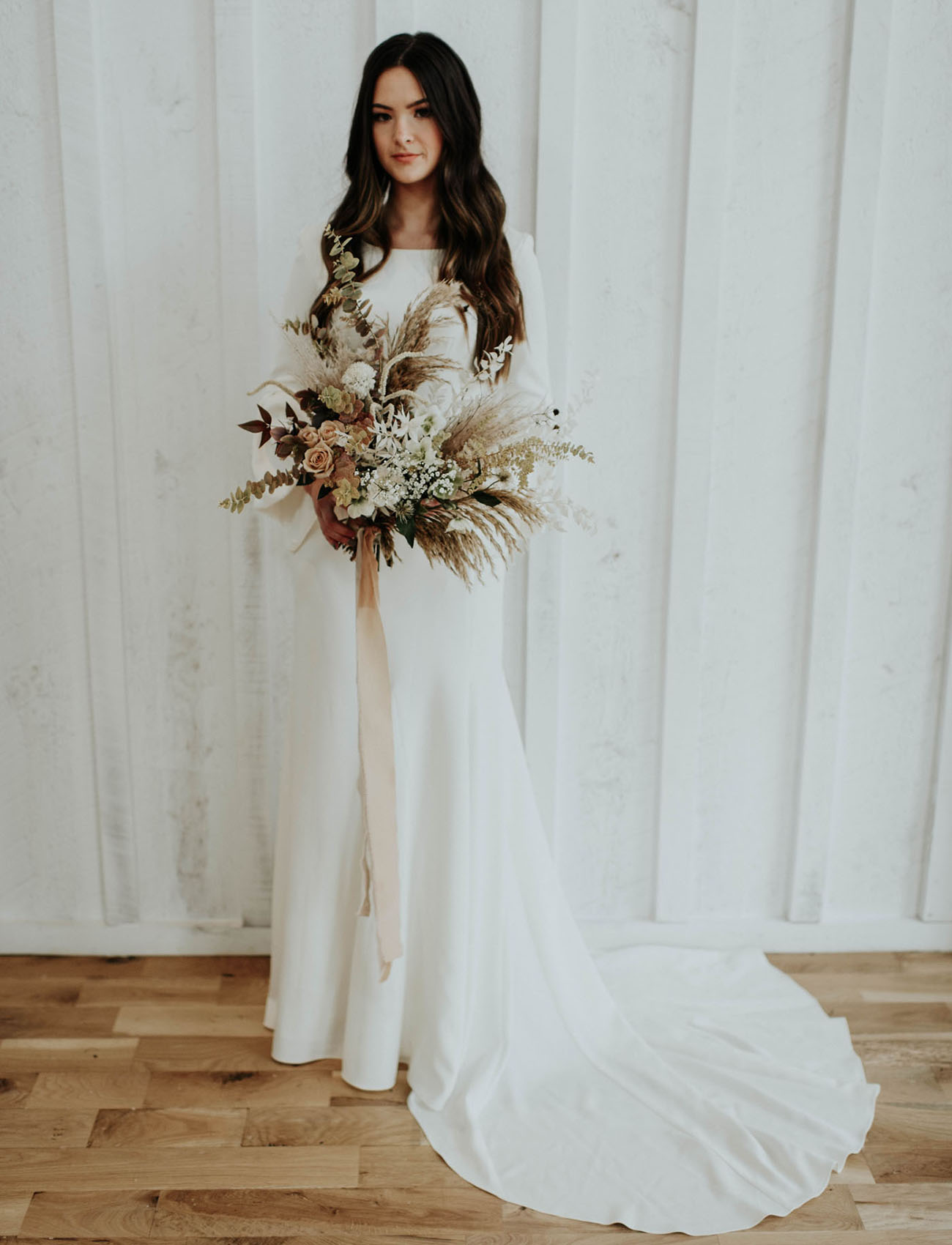 The bride was wearing a modern wedding dress with a high neckline, bell sleeves and a train