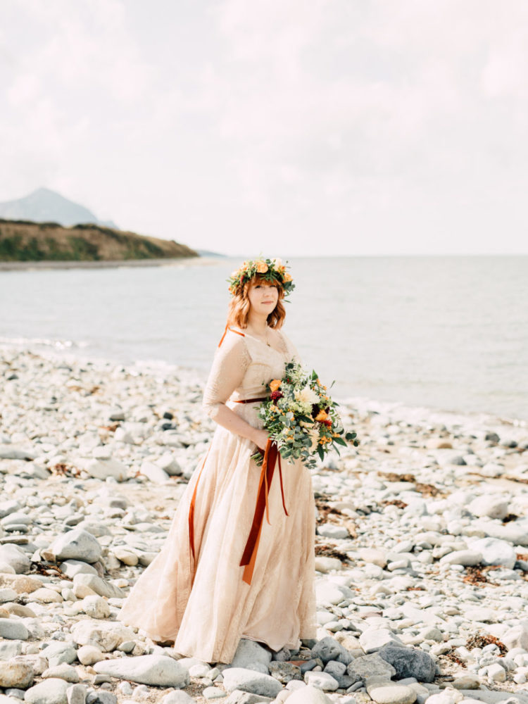 The bride was wearing a neutral lace wedding dress with illusion sleeves and a floral crown