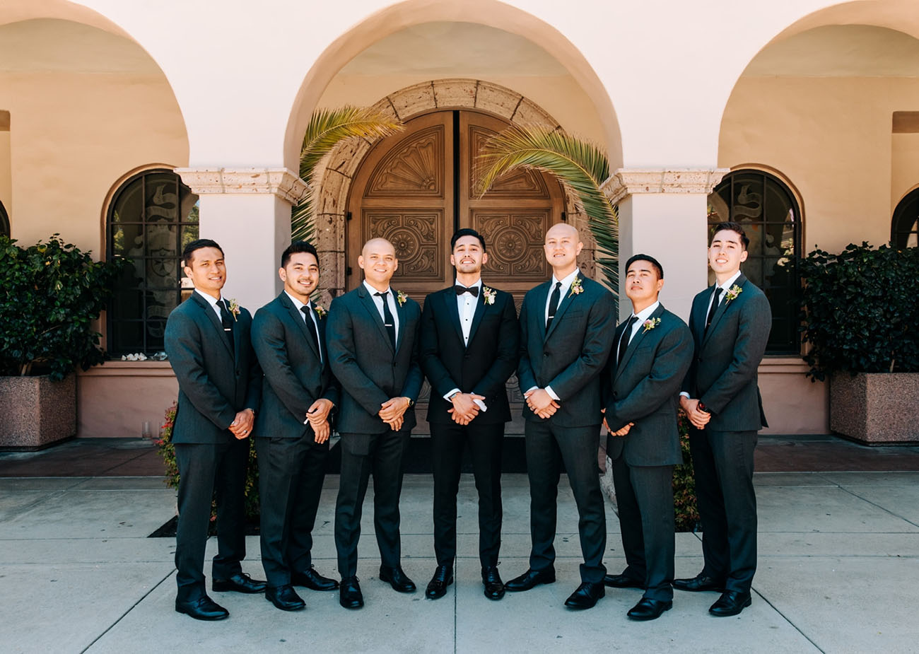 The groom was rocking and tuxedo and the groomsmen were wearing suits with ties