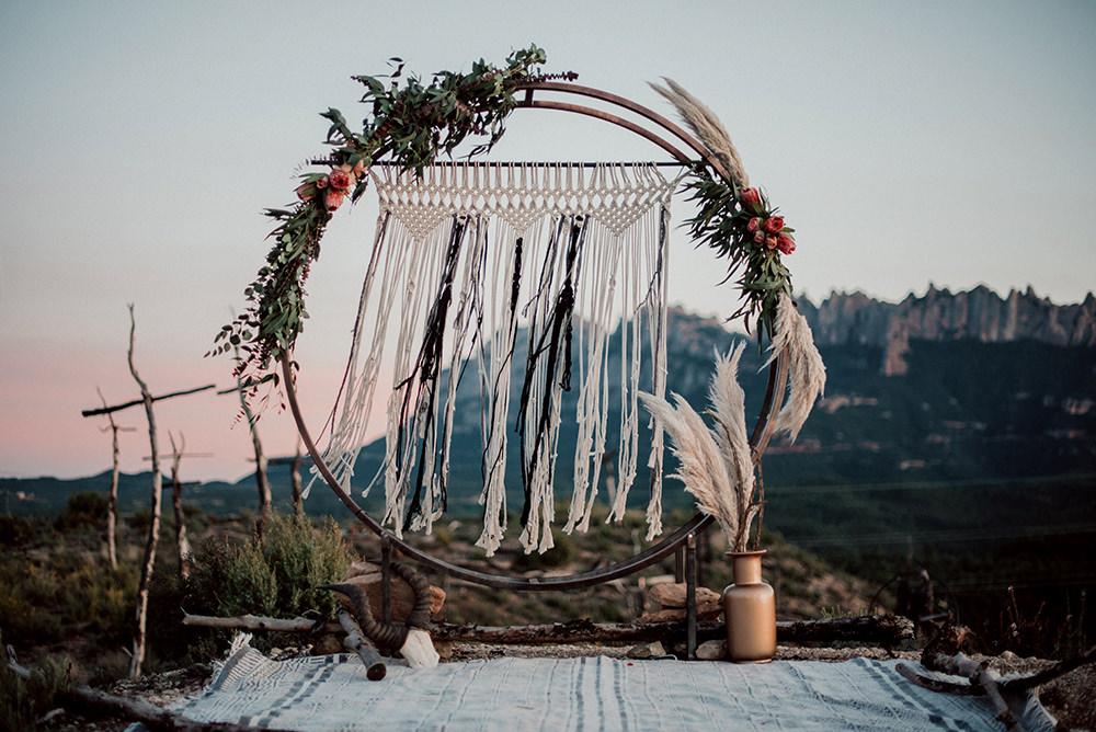 The wedding arch was a metal moon gate decorated with fresh blooms, greenery and grasses and macrame