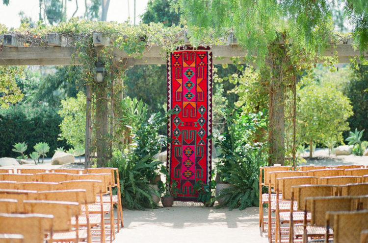The wedding ceremony space was done with a bright and colorful embroidered hanging