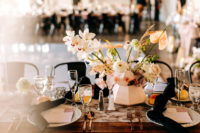 09 The tablescape was done in blush and black, too, with lush floral centerpieces, elegant cutlery and a printed runner