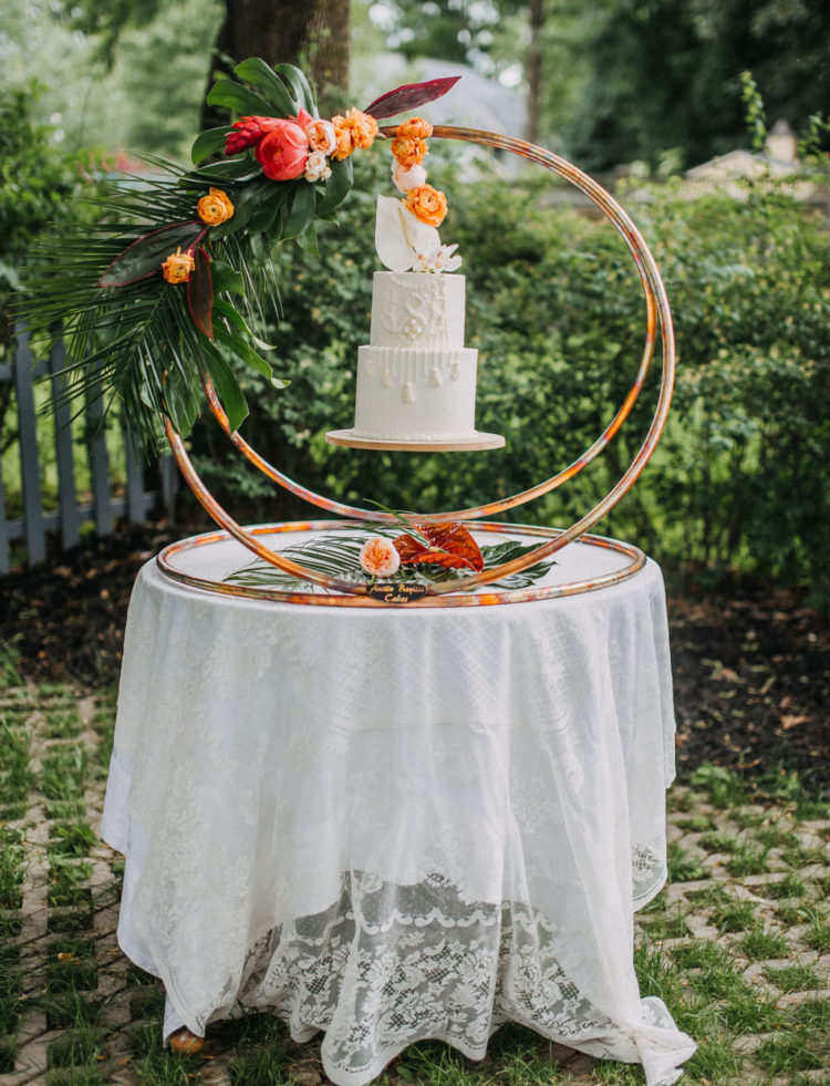 The wedding cake was displayed in an original way, it was floating in the copper rings decorated with fronds and blooms