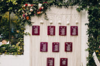 10 The wedding seating chart was done with macrame and burgundy seating cards plus blooms