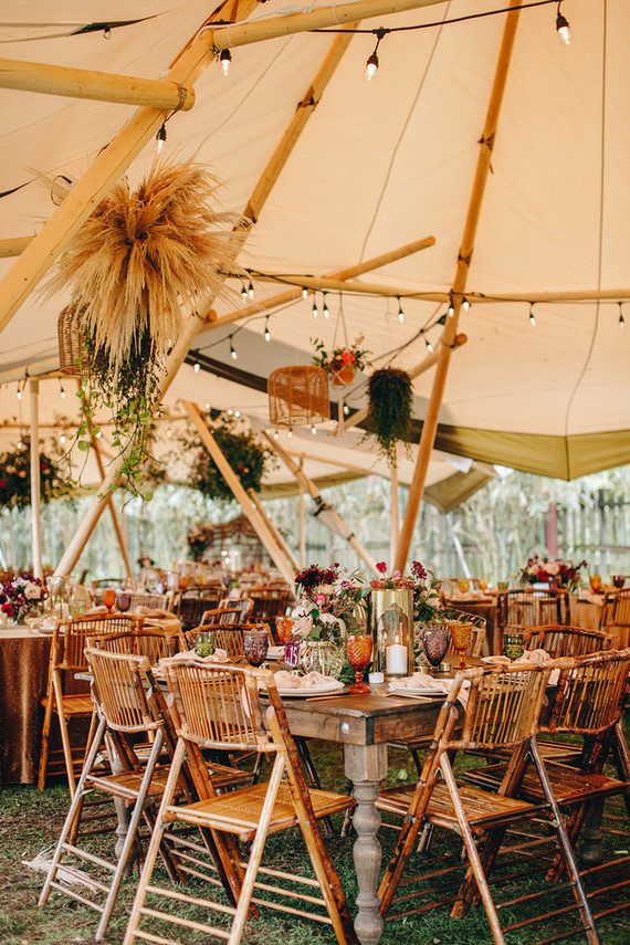The teepee was decorated in a bold boho way, with overhead decor, lights, colored glasses and blooms