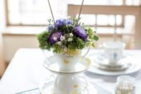 11 an elegant and whimsy wedding centerpiece with teacups, bright blooms and a banner on top
