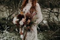 15 a moody fall bride wearing a unique metallic crown and long red hair down for a bold statement look