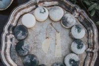 21 watercolor grey and white macarons that are showing the phases of the moon are amazing for your wedding dessert table