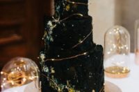 22 a black textural wedding cake showing off space and decorated with LEDs to mark stars