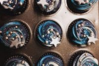 26 watercolor navy and blue swirl wedding cupcakes with beads and stars on top for your dessert table
