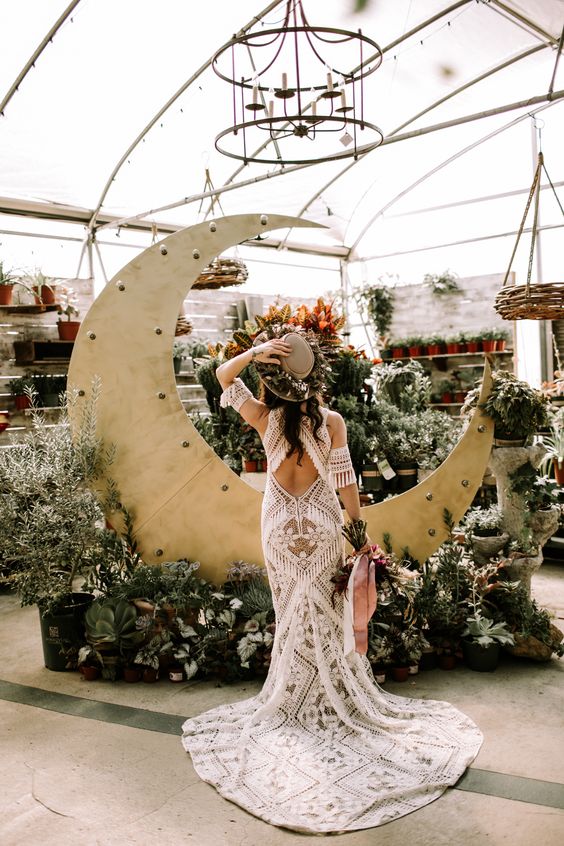 a boho celestial wedding altar of a half moon, greenery and white blooms is a cool and catchy idea for a wedding