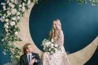 a celestial wedding altar of a half moon, white blooms and greenery is a catchy and chic idea for a boho wedding