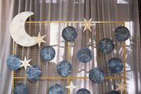 a glam seating chart with a half moon, stars and black and white moon pieces is a cool idea for a celestial wedding
