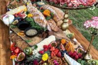 a grazing table done with different layers to incorporate everything from bread sticks and fruits to proschiutto and various sauces