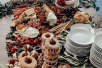 a cool grazing table decor with donut stands