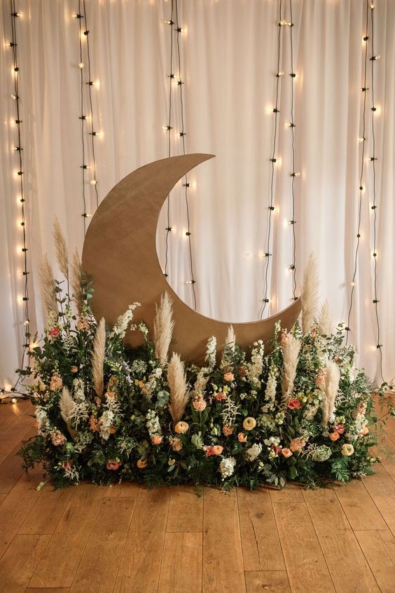 a pretty celestial wedding altar with a half moon and a lush floral arrangement with pampas grass is a cool idea
