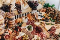 a small yet rich multi-layer grazing table with much bread and charcuterie, cheese, berries and fruit plus glazed donuts on sticks