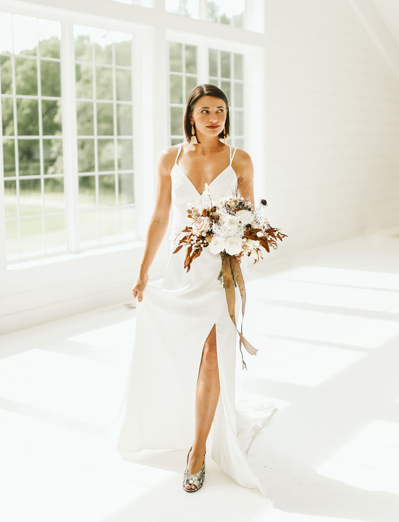 The bride was wearing a sleek minimalist wedding dress, bold printed shoes, statement earrings and a sleek bob