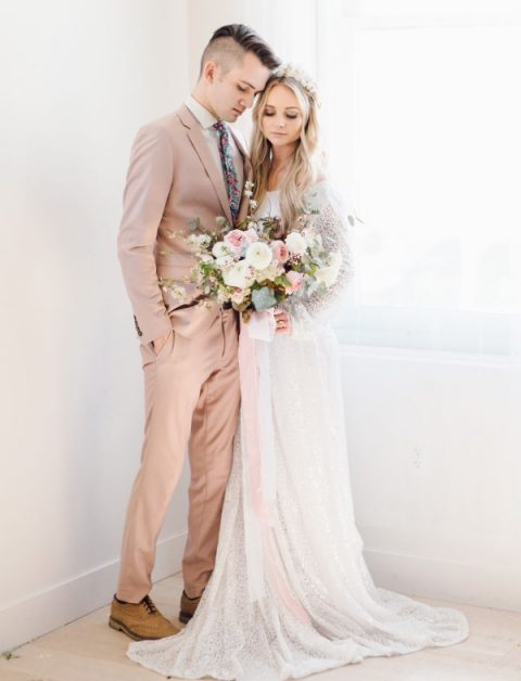 a blush suit, a white shirt, a colorful floral print tie and tan shoes for a chic spring groom's outfit