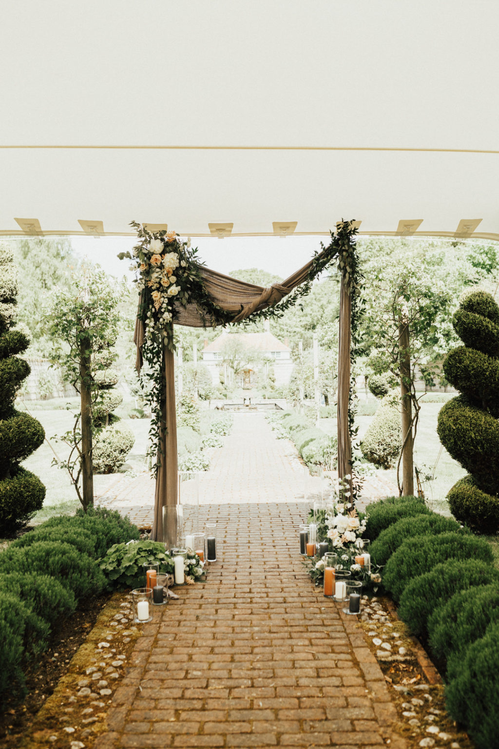 The wedding arch was decorated with burlap, blooms, greenery and with candles on the ground