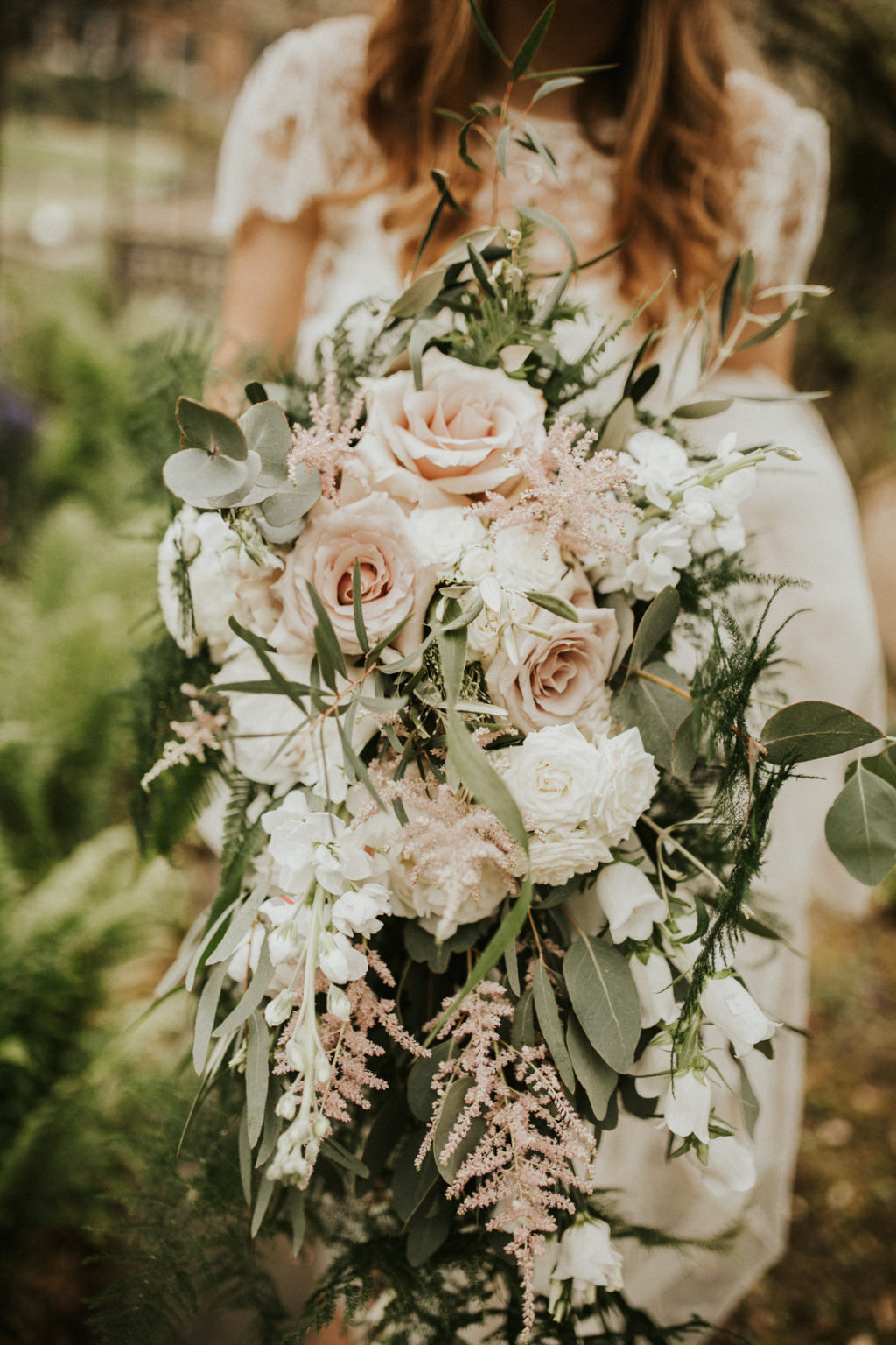 The wedding bouquet was lush and neutral, with blush and white blooms and cascading greenery