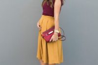 06 a burgundy top with no sleeves, a marigold knee pleated skirt, a burgundy clutch and two tone block heels