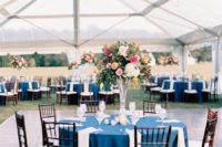 07 The wedding tablescapes were done with navy tablecloths, bright and textural florals and candles