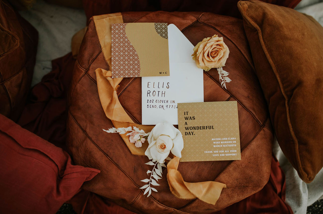 A chic 70s inspired wedding invitation suite done in gold, brown and with patterns