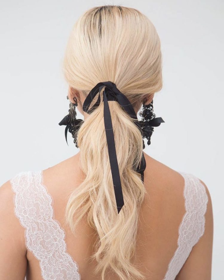 a wavy ponytail with a black ribbon and matching black lace and ribbon earrings by Marchesa