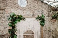 09 a tropical 70s inspired wedding ceremony space with a macrame and tropical leaf arch, bottles, candles and rugs