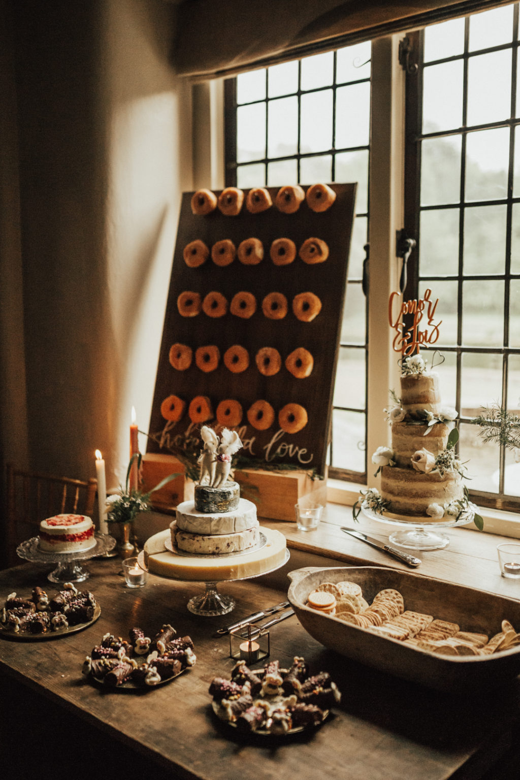 a wedding dessert table with a donut wall