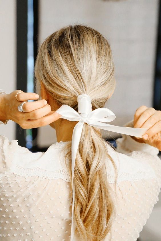a low ponytail plus a ribbon hair wrap and a bow to highlight your hairstyle and make it catchy