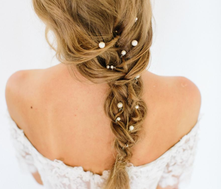 a messy bridal braid spruced up with pearl pins is a very chic and romantic idea
