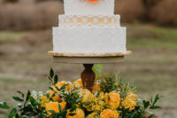 19 a bold 70s inspired wedding cake with various patterns, bold sugar blooms and served on a stand with blooms