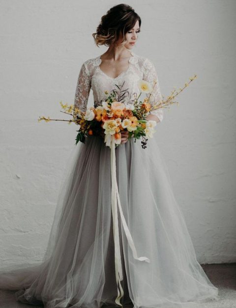 a chic bridal look with a grey tulle skirt and a white lace top with long sleeves for a modern romantic bride