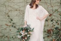 19 a lace sheath wedding dress with bell sleeves, a train, a V-neckline for a boho 70s inspired bridal look
