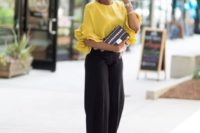20 a casual yet outfit with black culottes, a sunny yellow top with ruffled sleeves, black spike shoes and a black clutch