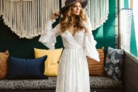 20 a lace wedding dress with bell sleeves, a train and a grey hat for a boho chic 70s inspired look