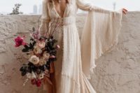 23 a pearled A-line wedding dress with a deep neckline, bell sleeves, a white hat and a train for a boho look