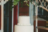 25 a white wedding cake decorated with macrame is very boho and hippie-like, which is great for a 70s wedding