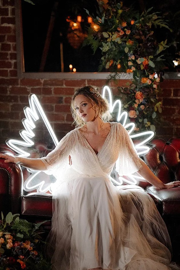 The bride was wearing an embellished wedding dress with a V-neckline and look at these neon wings