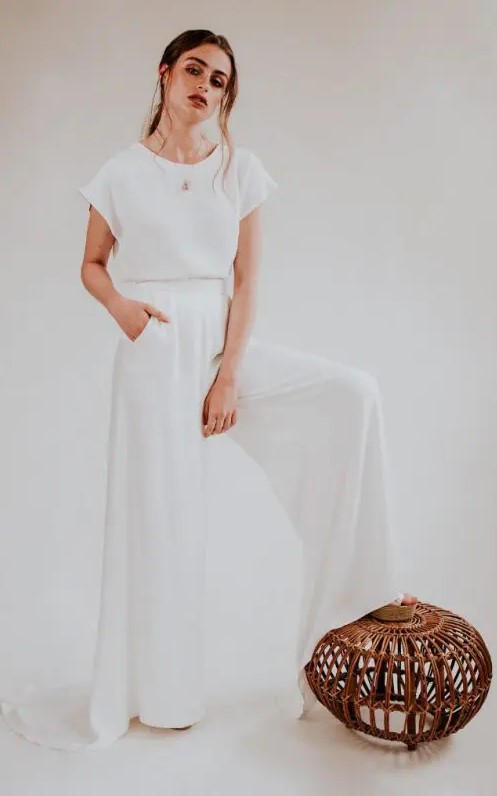 a 70s inspired bridal look with a white plain top with cap sleeves and wideleg pants with a train that remind of a skirt